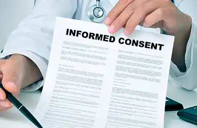 A doctor provides a piece of paper that reads: "Informed Consent" to a Massachusetts medical malpractice lawyer.