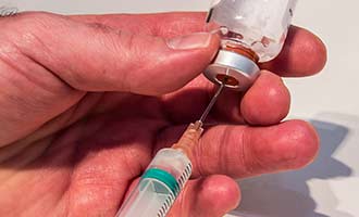 A needle injecting a substance before causing a needle related injury.