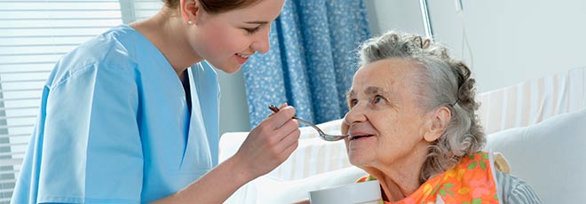 Assisted Living Facility nurse feeding elderly woman