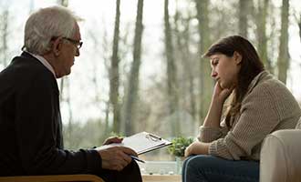 A psychiatrist speaks to his client during a session. 