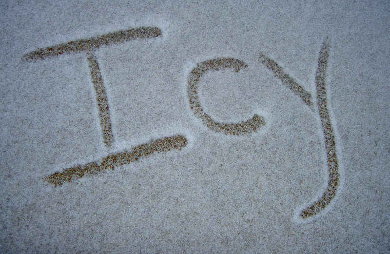 Icy written in show on slippery sidewalk