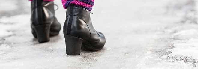 woman walking on frozen ice in boots