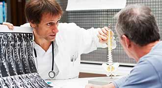 Doctor talking to patient with spinal cord disc injury from car accident and showing where the problem is