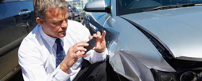 Insurance Claims Adjusters recording the damage of car for a report