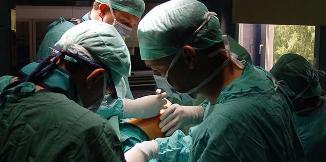 Stressed and fatigued doctors working on patient in operating room about to cause emergency room medical errors