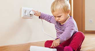 Young child playing near an outlet which can be avoided with outlet covers