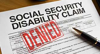 A Social Security lawyer has a document labeled: "Social Security Disability Claim" that has a red stamp on it labeled: "Denied."