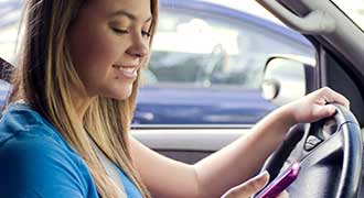 young woman texting and driving