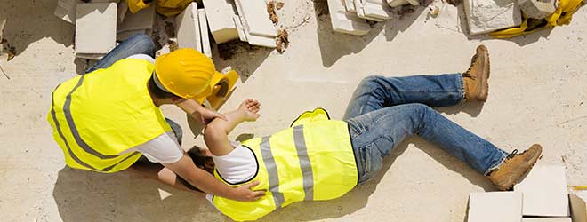 A construction worker on the floor in pain waiting for his slip and fall lawyer to arrive.