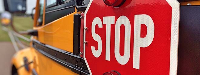 School bus with stop sign taking children back to school