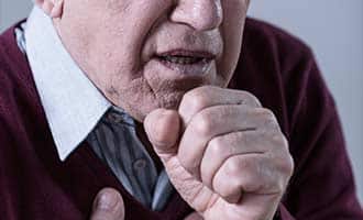 man with asthma coughing