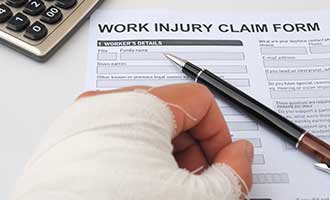 worker filling out a Personal Injury claim form for RI Workers’ Compensation