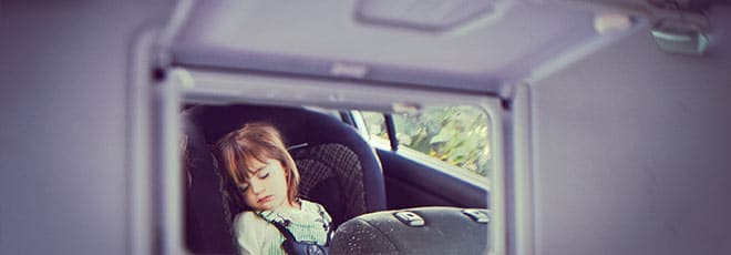 child sleeping in back seat of a hot car