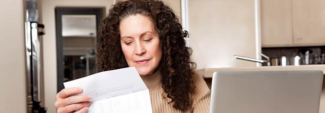 A woman reading a letter that her car accident lawyers sent.