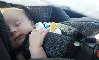 Baby in the car seat of a defective automobile.