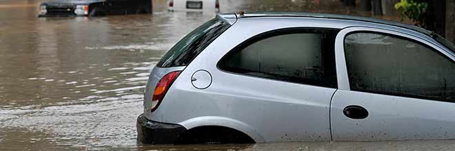 hurricane damaged vehicles in flooded street