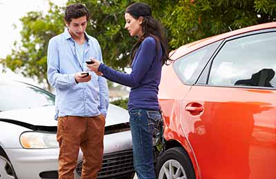 two people exchanging insurance after a car accident