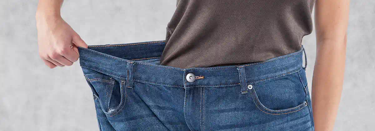A man in jeans twice his size after losing weight using the dangerous drug Belviq.