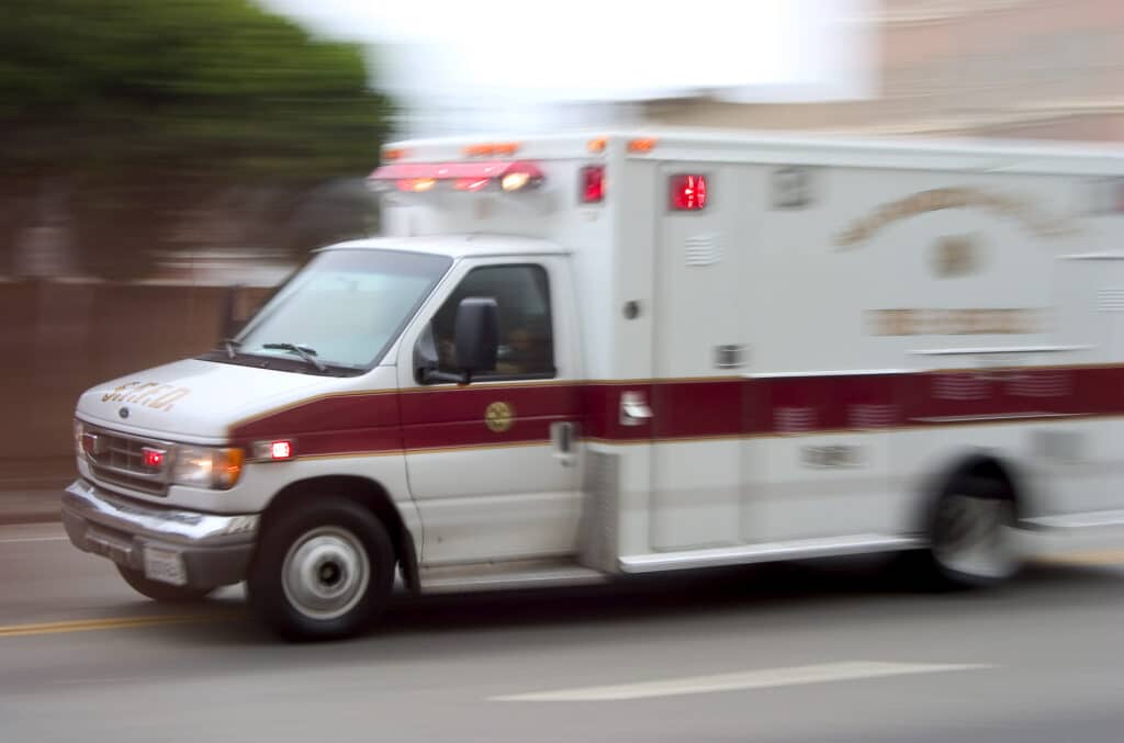 An ambulance leaving the scene of a motorcycle accident.