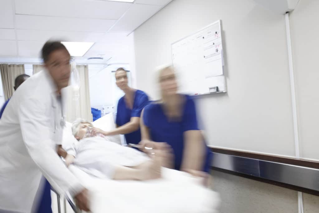 A team of doctors rushing a patient down the hallway