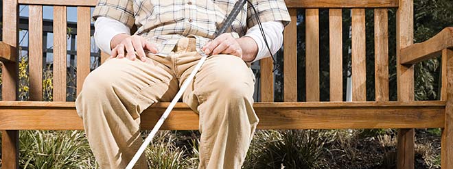 Blind man sitting on a park bench