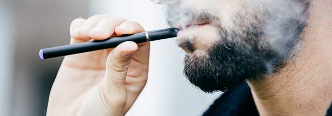 A man smoking an e-cigarette.