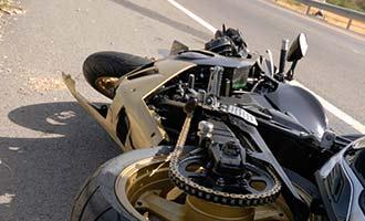 A Massachusetts motorcycle accident lawyer is documenting the scene of a crashed motorcycle.