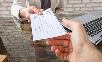 A Massachusetts motorcycle accident lawyer is handing their client a settlement check.