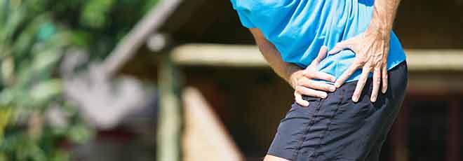A runner holding his hip in pain. 