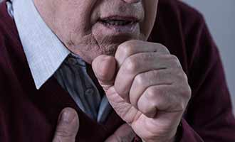 older man coughing in pain 