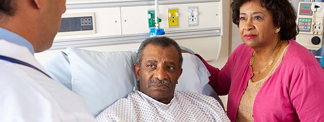 A doctor talking to a man in a hospital bed about a surgical error.