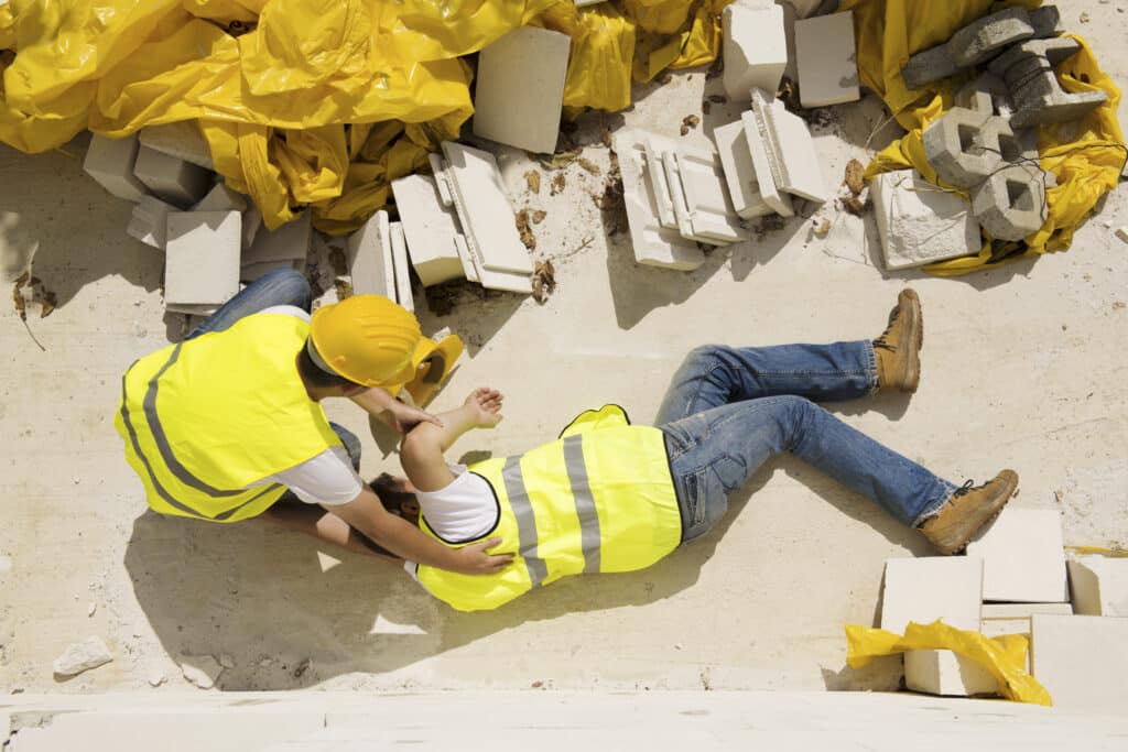 Worker falling off staging being helped by a co-worker