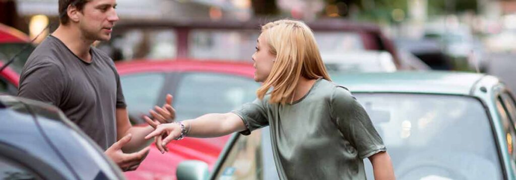 Woman arguing with a man after a car accident