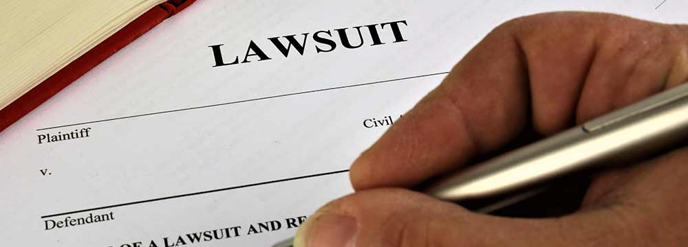 Someone filling out a lawsuit claim form. 