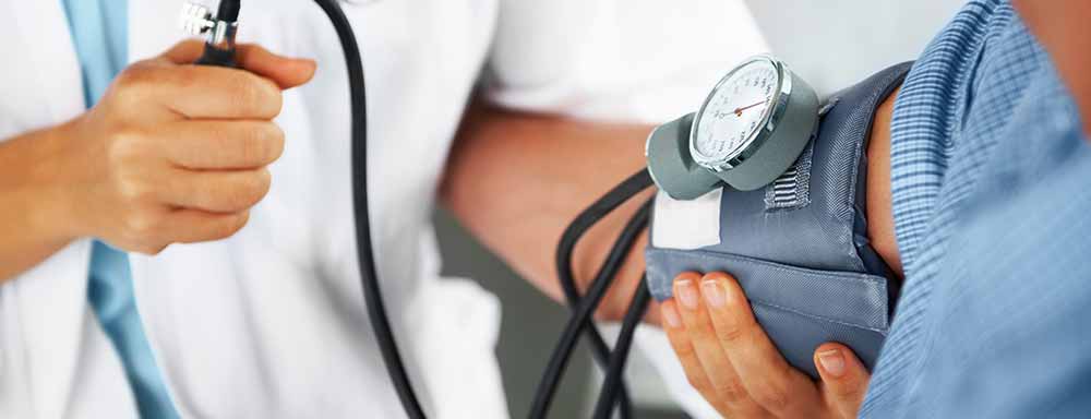 A doctor taking the blood pressure of a patient.