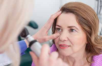 A woman having her eye examined by a doctor. 