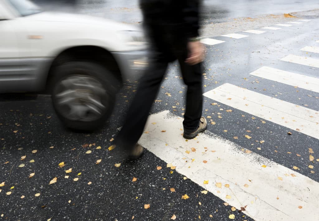 Pedestrian in crosswalk about to get hit by a car