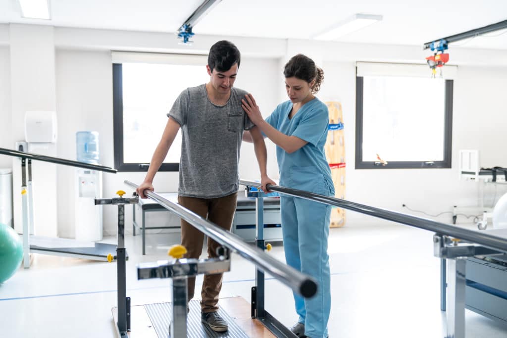 A nurse helping a patient during rehab.