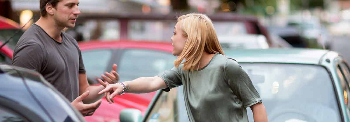Man and woman arguing after a car accident