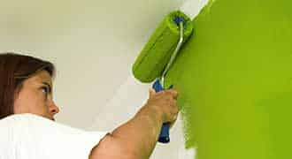 Woman painting wall with a roller