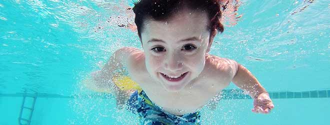 young boy under water in swimming pool