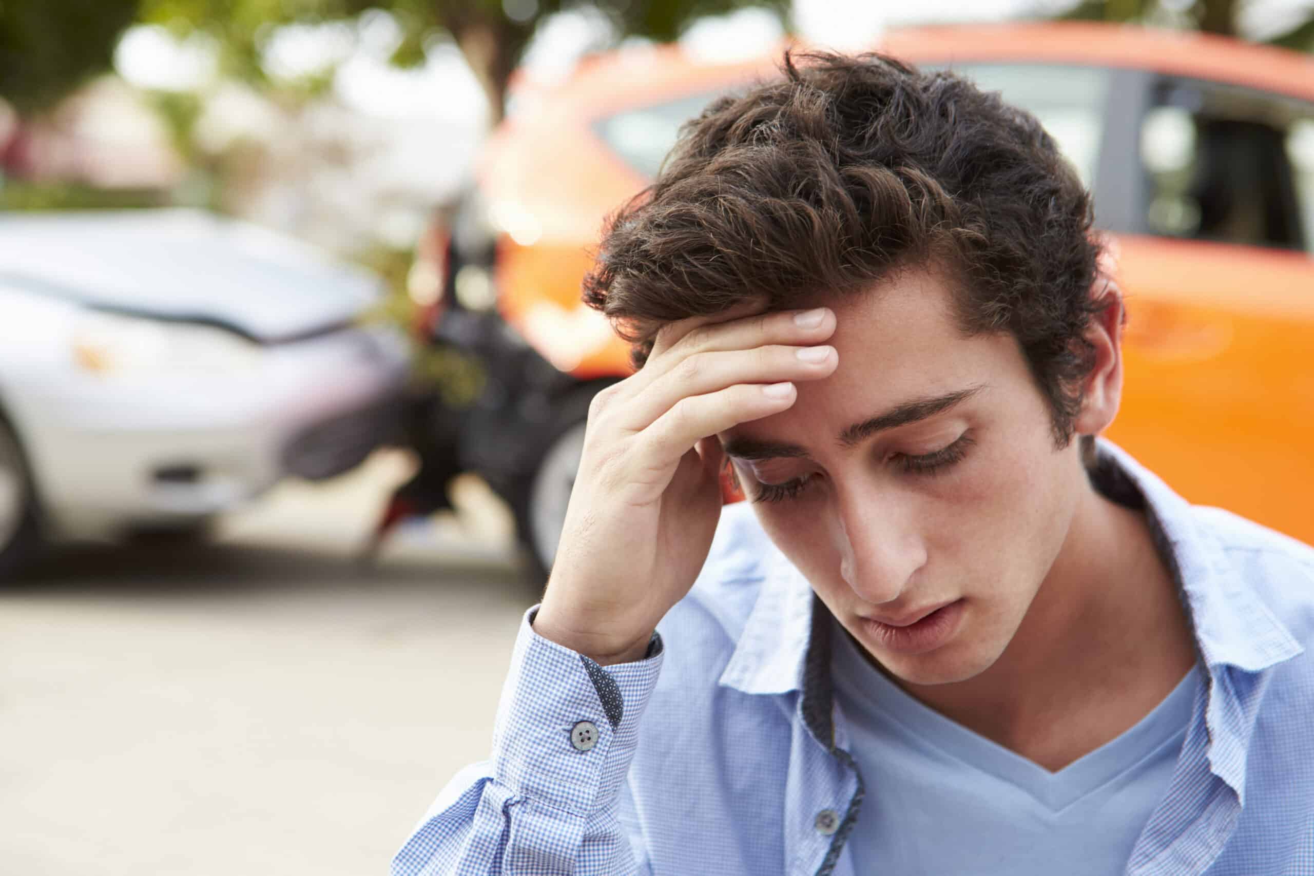 A concerned driver at the scene of a car accident.