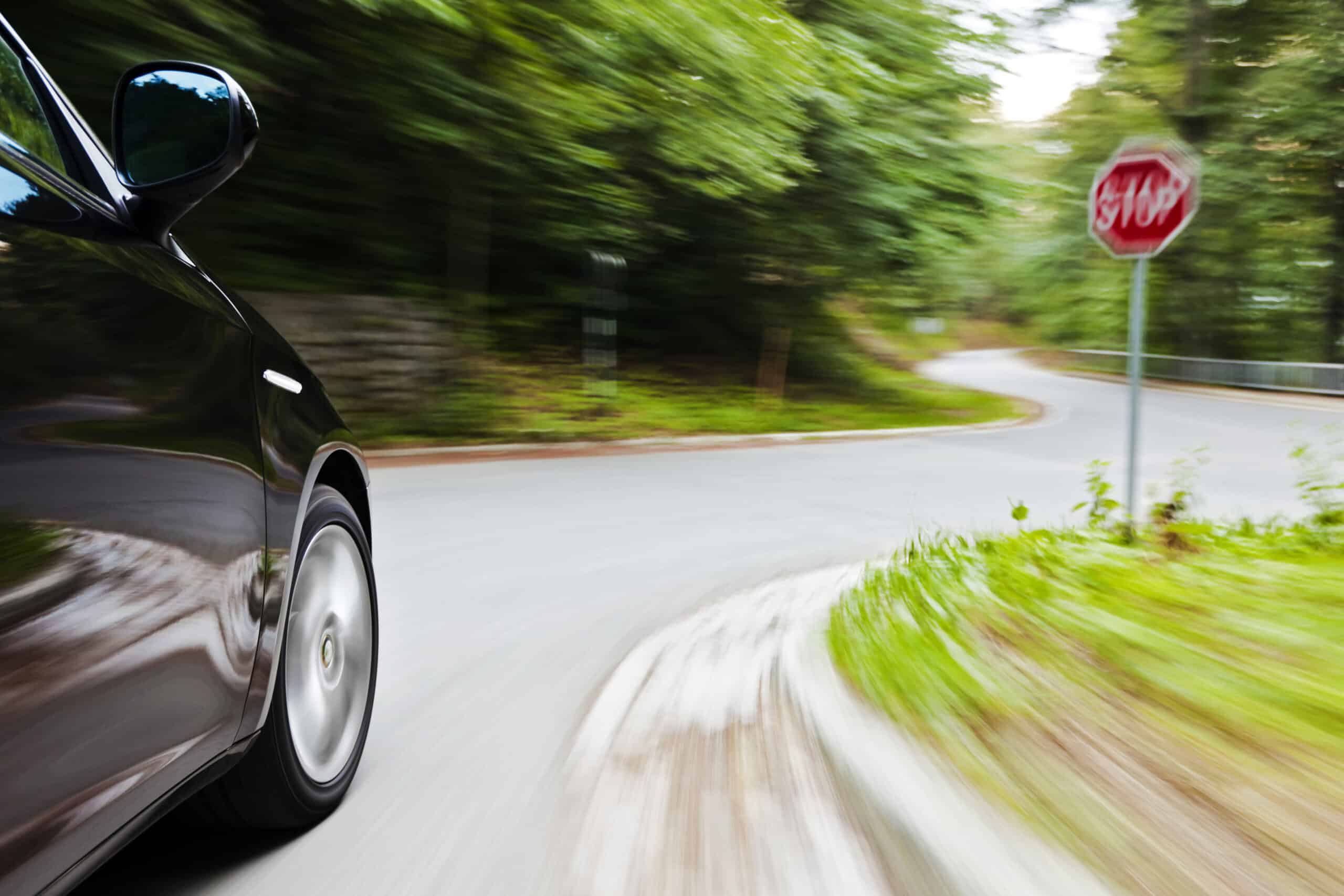A car speeding past a stop sign.