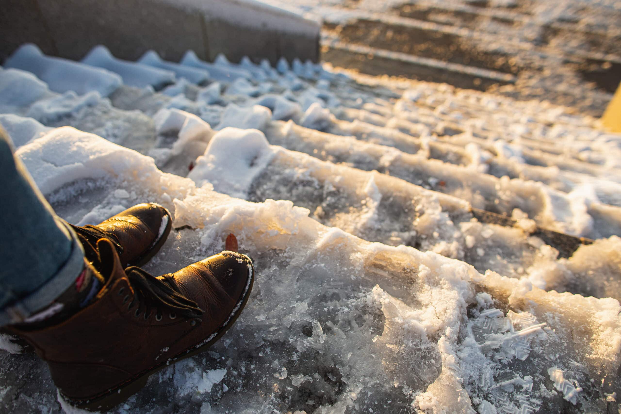 Someone about to take a step down very icy stairs.
