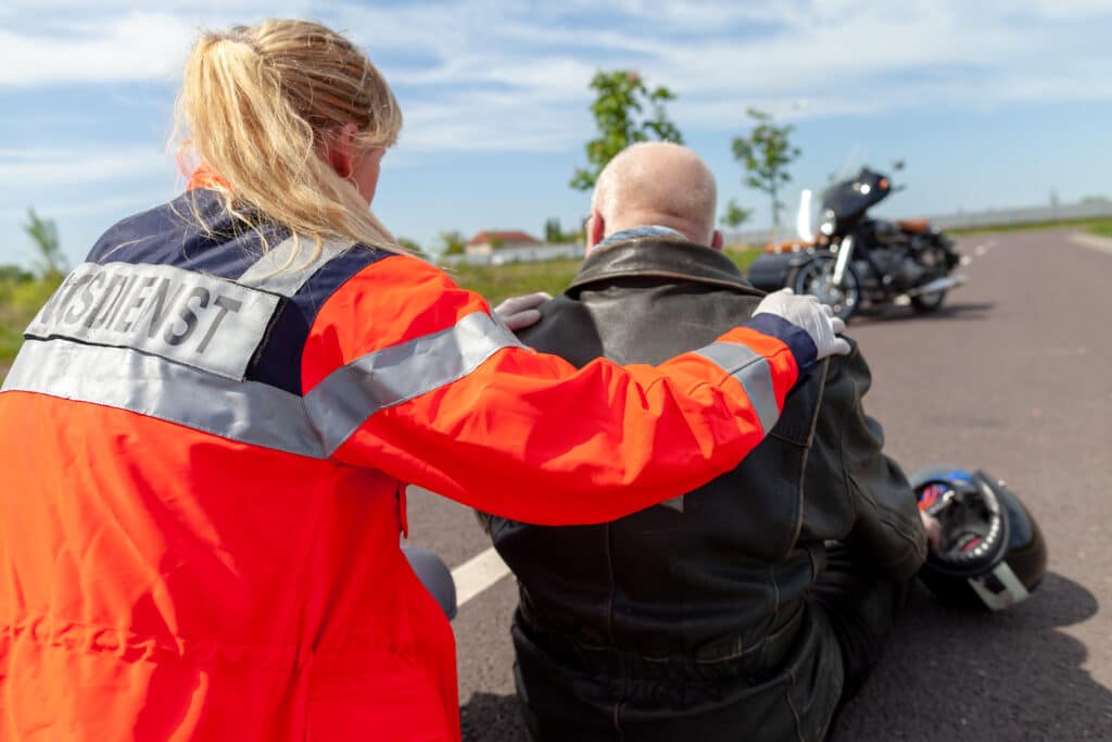 Motorcycle rider being helped by a paramedic
