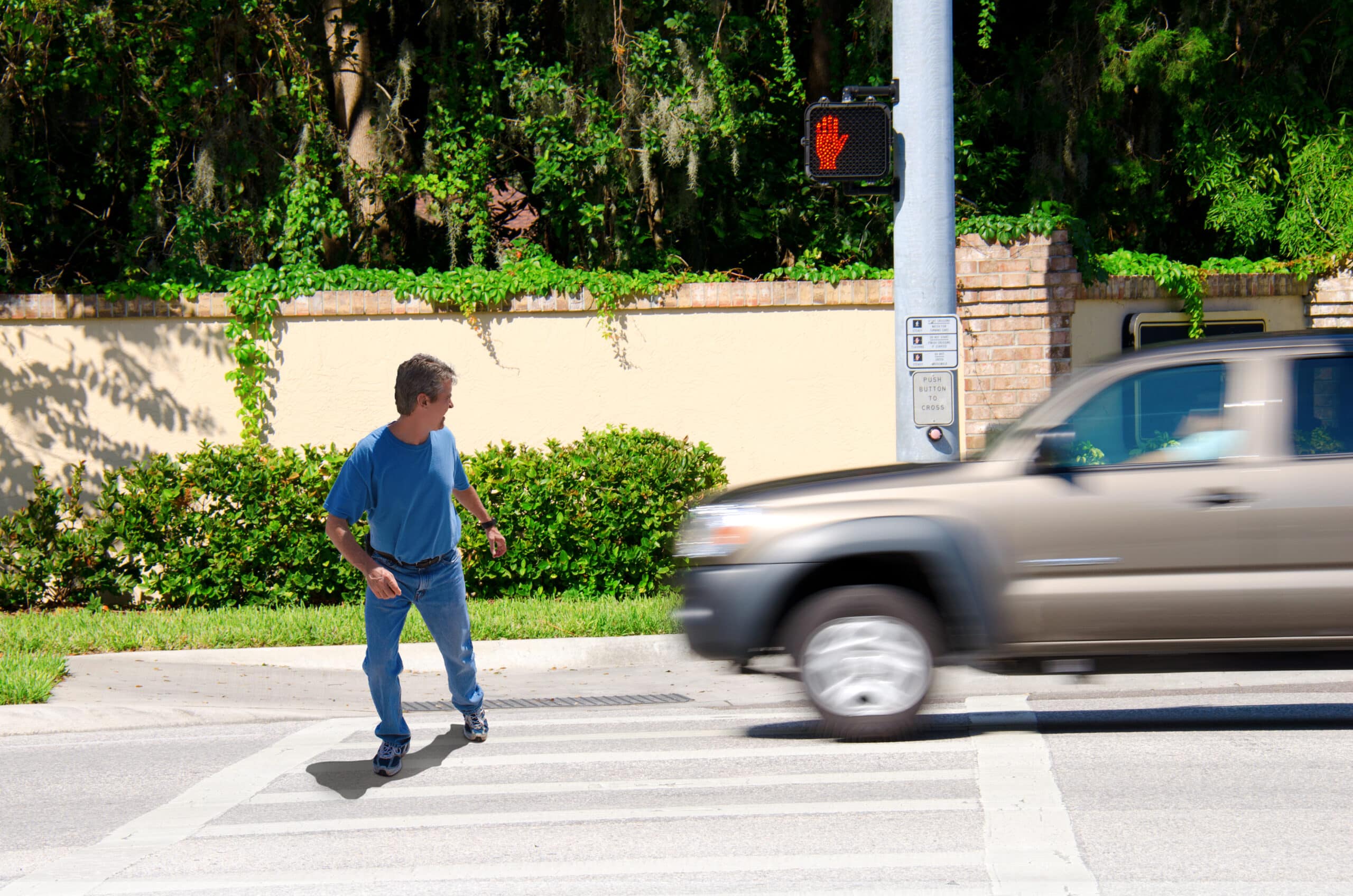 A pedestrian in a crosswalk about to be hit by a truck.
