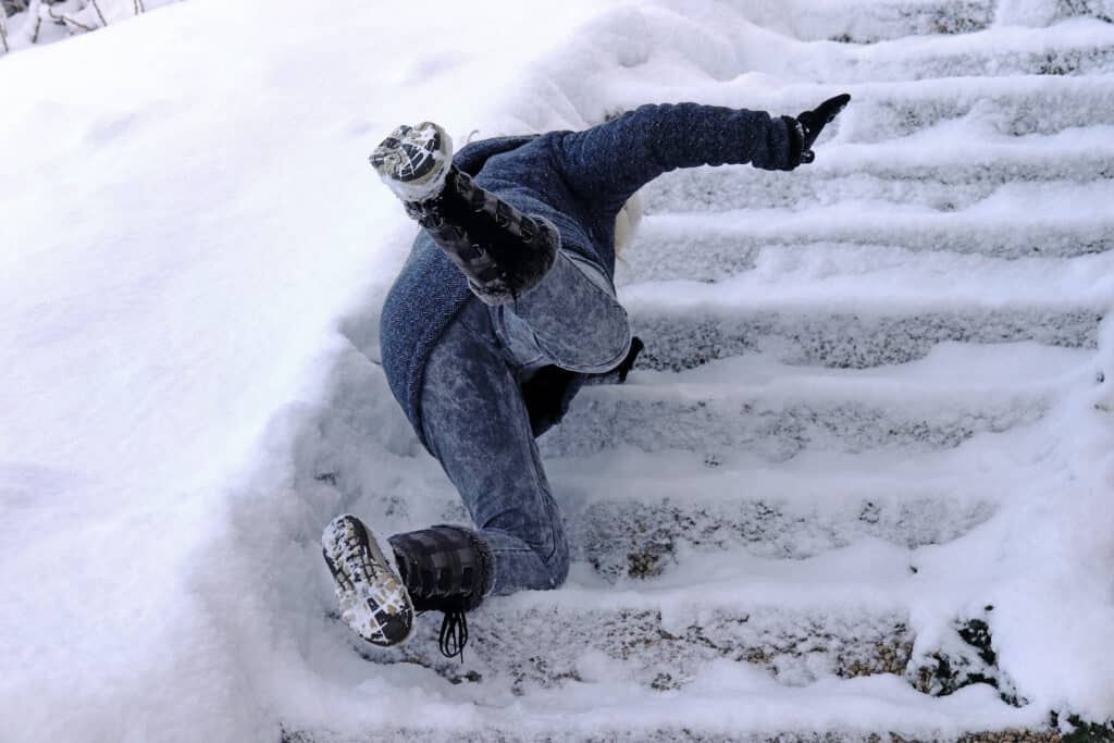 Someone falling down untreated icy stairs.